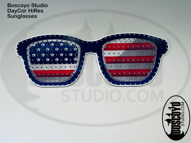 Sunglasses with American flag design on a white background, branded 'Boscoyo Studio'.